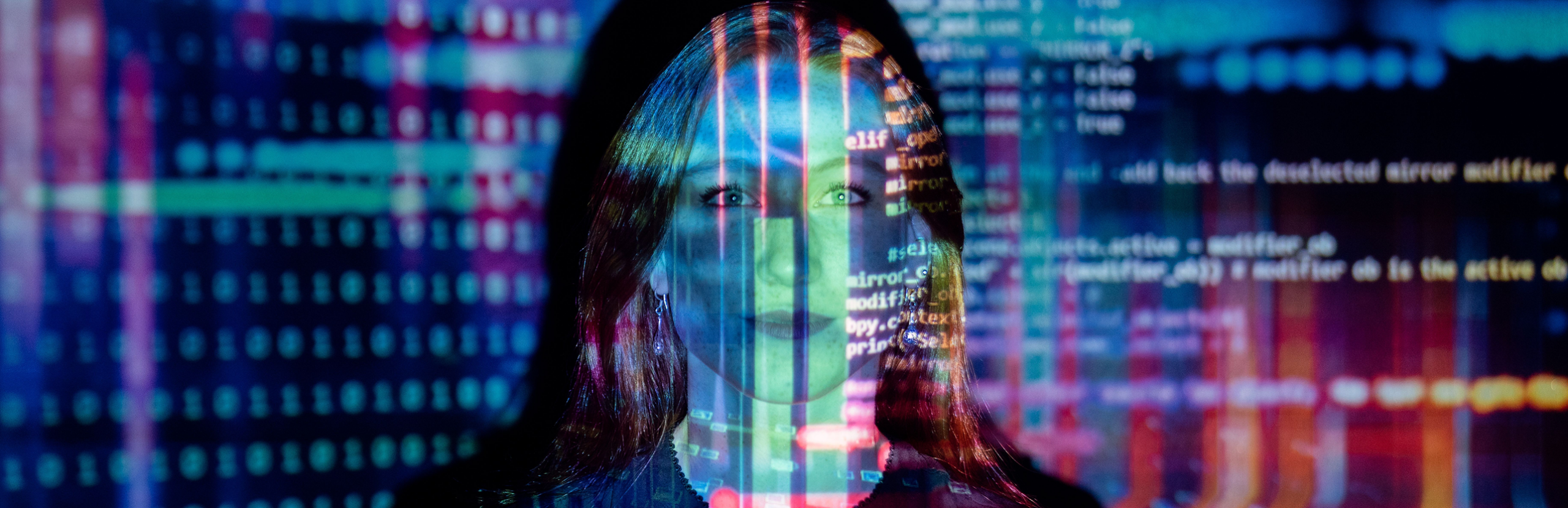 A woman's face overlaid with colorful digital code and binary patterns in blue, red, and green tones.